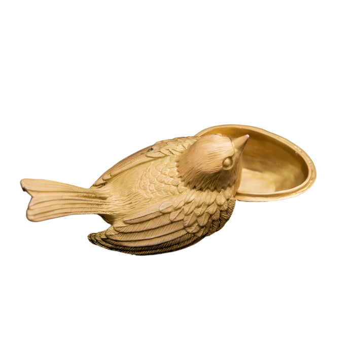 Gold bird-shaped trinket box on a black background